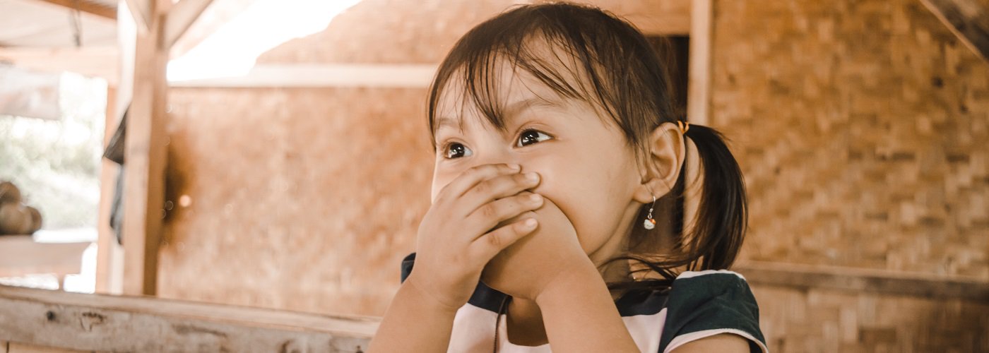 Young child covering mouth, possibly indicating sore throat or ENT discomfort.